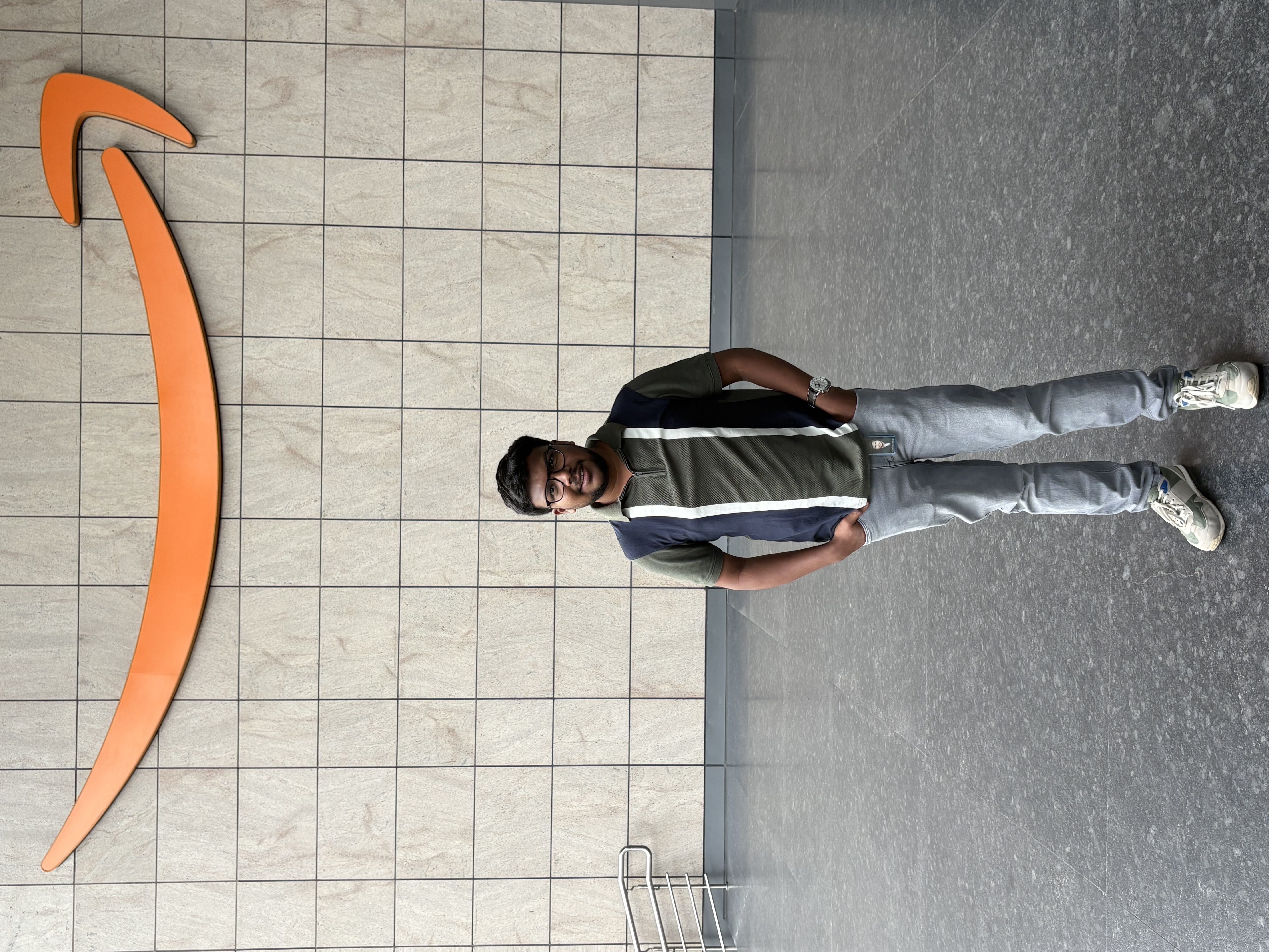 Shabul Hussain next to Amazon arrow logo in lobby