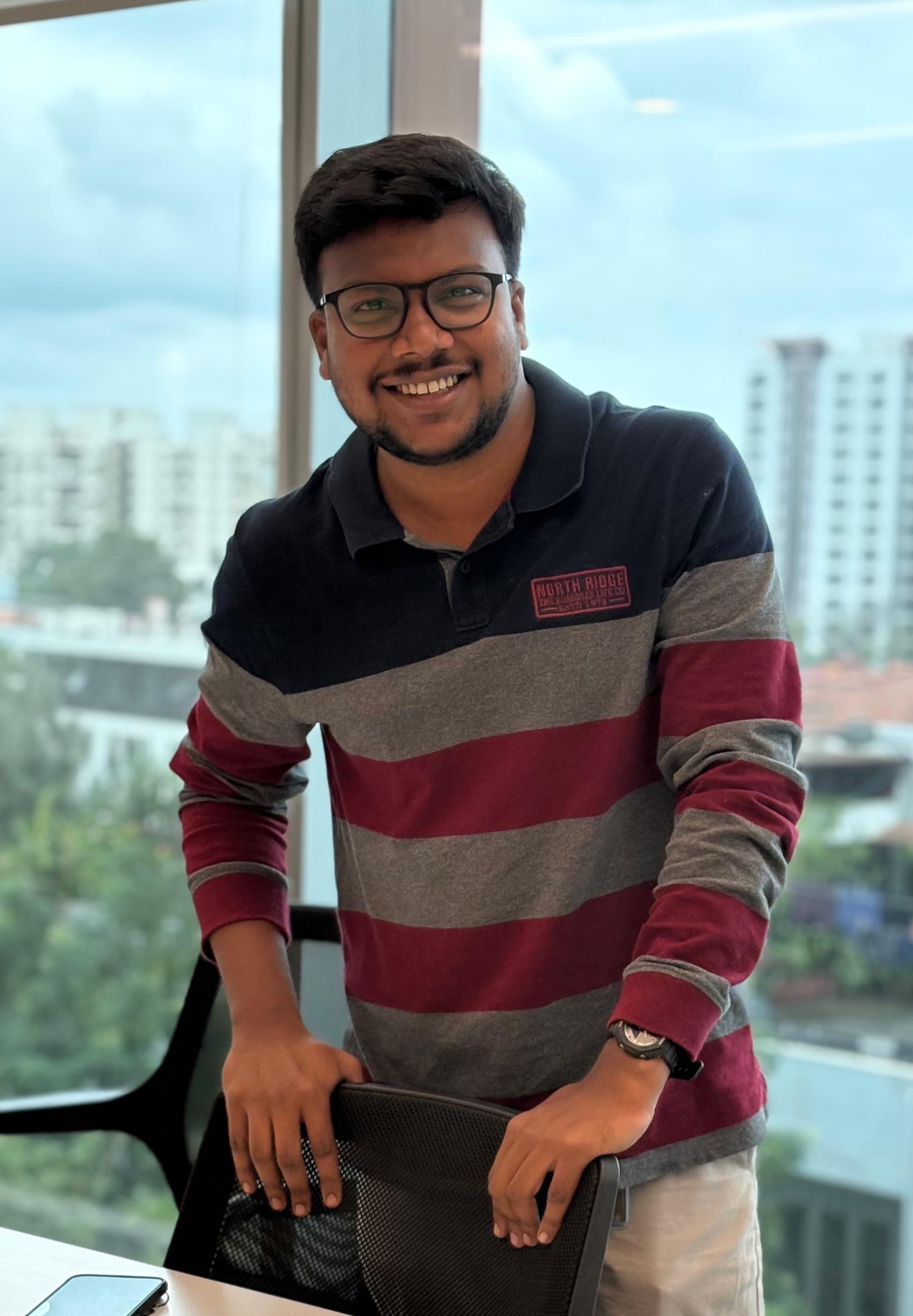Shabul Hussain Abdul smiling at office window