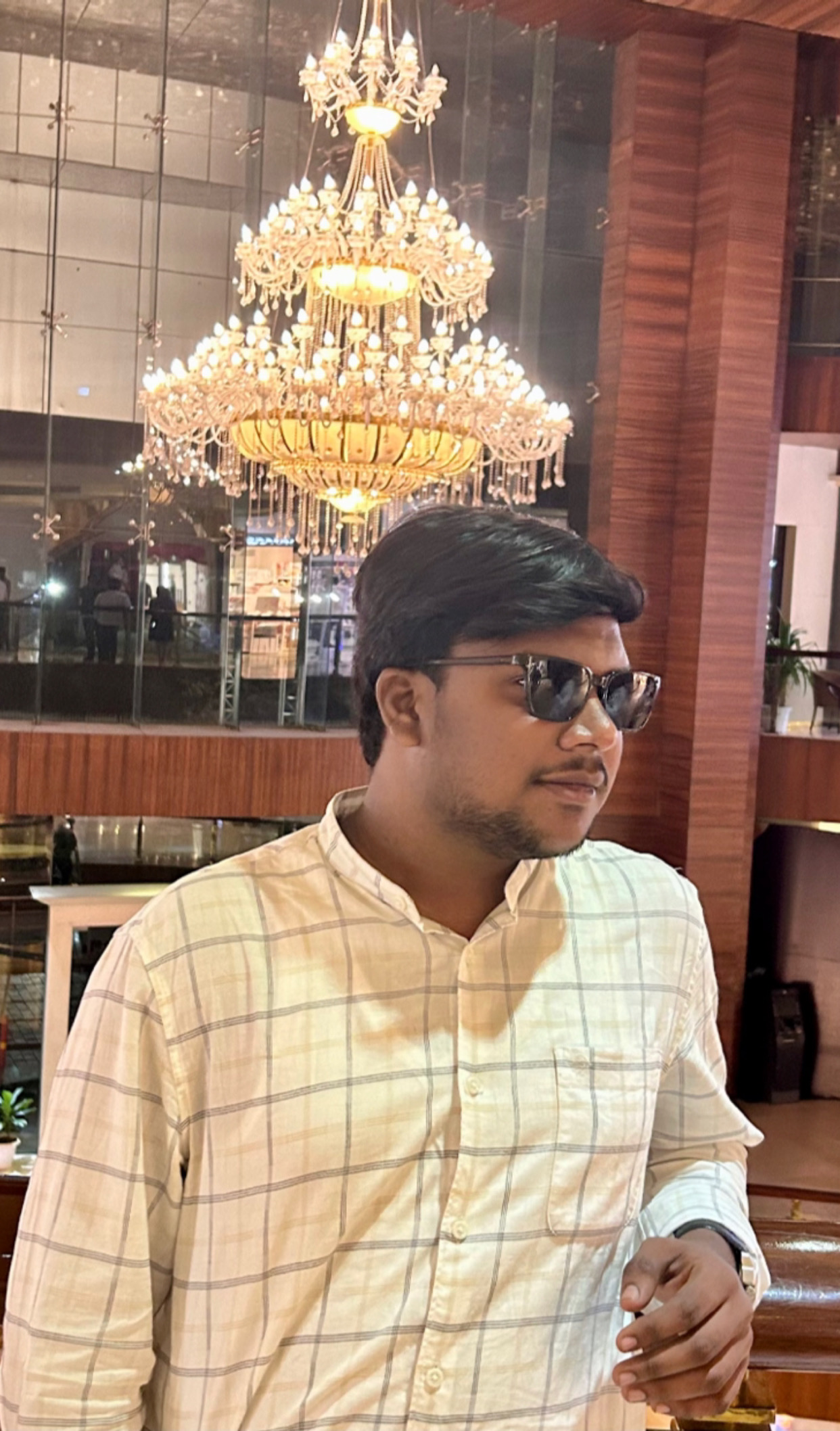 Shabul Hussain wearing sunglasses under grand chandelier